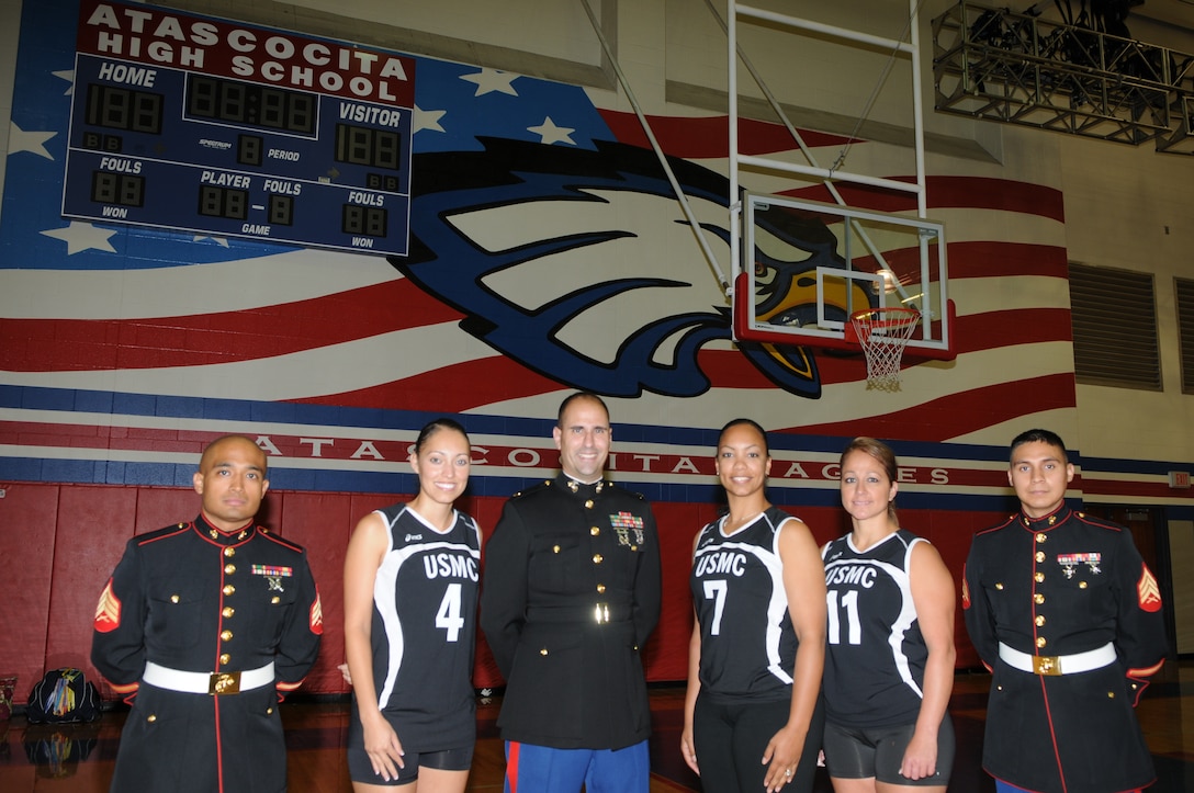 All-Marine volleyball team members Cpl. Lisa Tijerina (jersey number four); Staff Sgt. Nyla James (jersey number seven); and Gunnery Sgt. Vanessa Delgado (jersey number 11) stand with RS Houston commanding officer, Maj. Jason Borovies and the recruiters of RSS Humble at Atascocita High School as part of the station’s FY11 Operation HVT (High Value Target) mission.